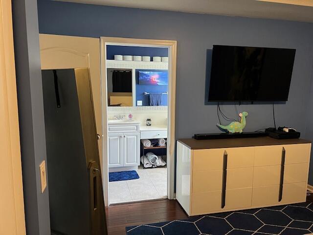 bedroom featuring dark wood-style flooring and connected bathroom