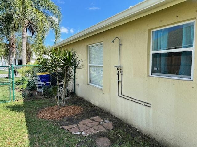 view of home's exterior featuring a yard, fence, and stucco siding