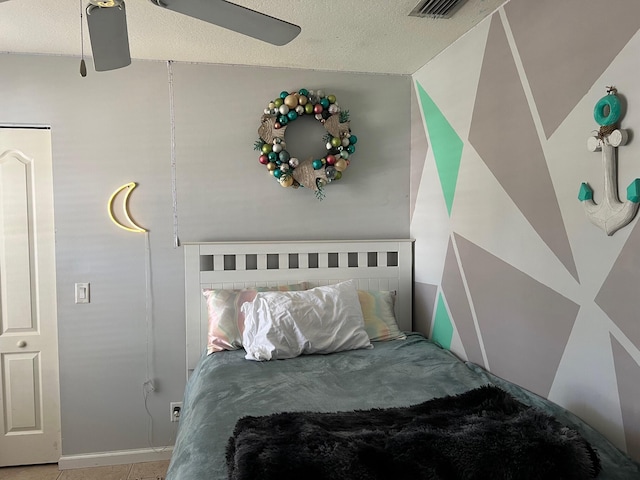 bedroom with a ceiling fan, visible vents, and a textured ceiling