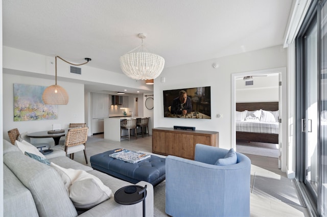 living area featuring visible vents and an inviting chandelier