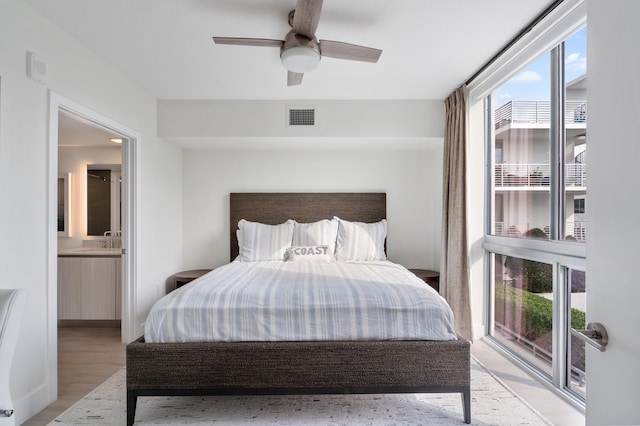 bedroom with connected bathroom, a ceiling fan, visible vents, access to exterior, and light wood finished floors