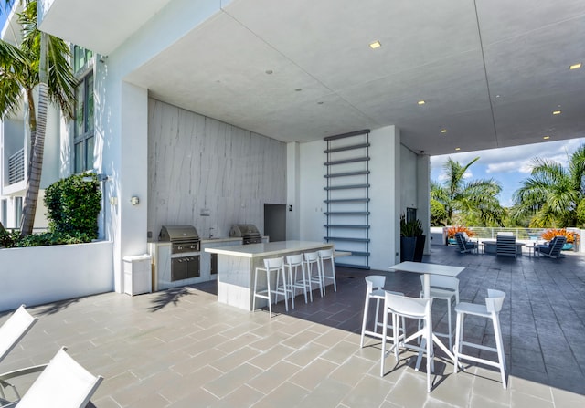 view of patio / terrace with an outdoor hangout area, exterior kitchen, area for grilling, and outdoor wet bar