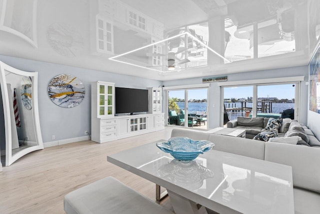 living area with an inviting chandelier, baseboards, and wood finished floors