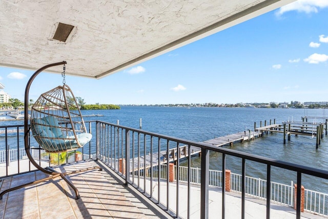 dock area with a water view and a balcony