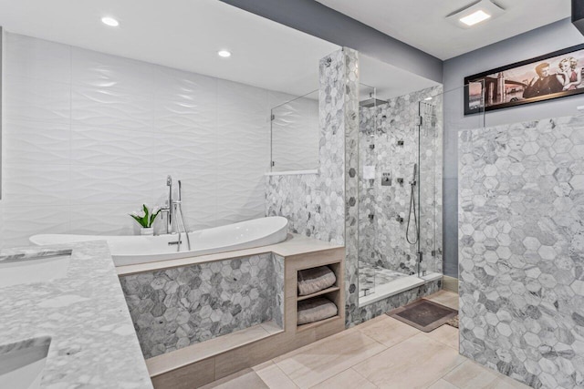 bathroom featuring tile walls, recessed lighting, a tile shower, a tub with marble appearance, and tile patterned flooring