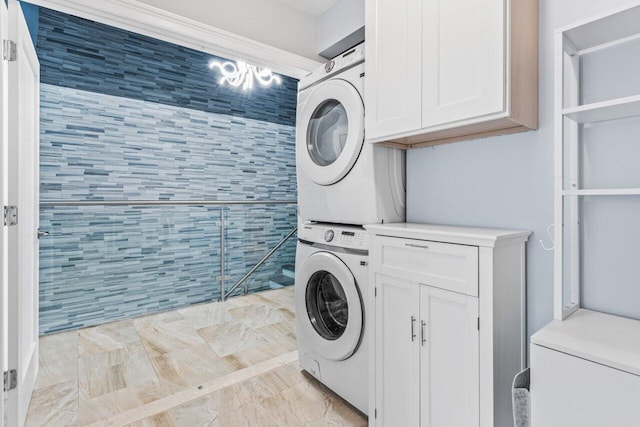 laundry room featuring cabinet space and stacked washer / drying machine