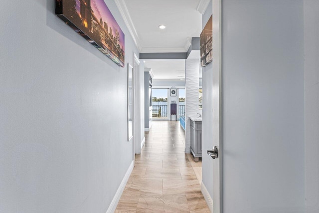 hall with baseboards and ornamental molding