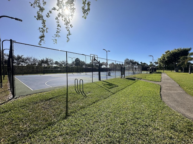 view of sport court with community basketball court, a yard, and fence