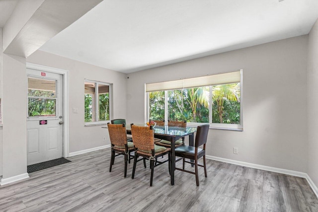 dining room with light wood-style flooring and baseboards