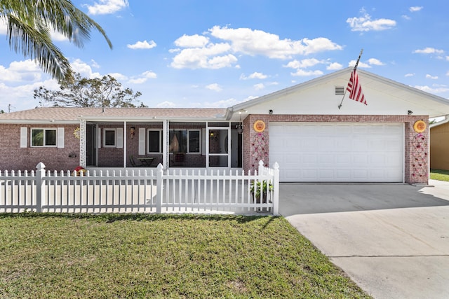 single story home with driveway, an attached garage, a front lawn, and brick siding