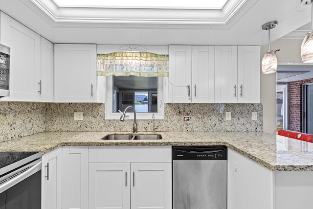 kitchen featuring light stone counters, a sink, white cabinets, stainless steel dishwasher, and pendant lighting