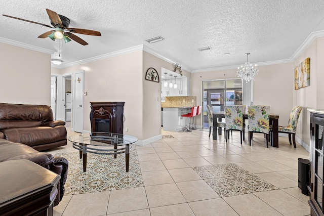 living area with light tile patterned floors, a textured ceiling, ceiling fan with notable chandelier, visible vents, and crown molding