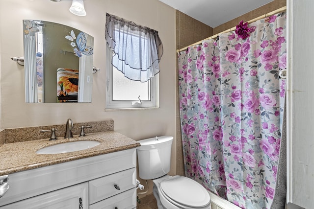 bathroom with toilet, a shower stall, and vanity