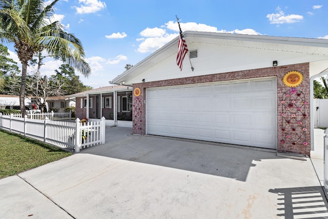 ranch-style home featuring fence private yard, brick siding, driveway, and an attached garage