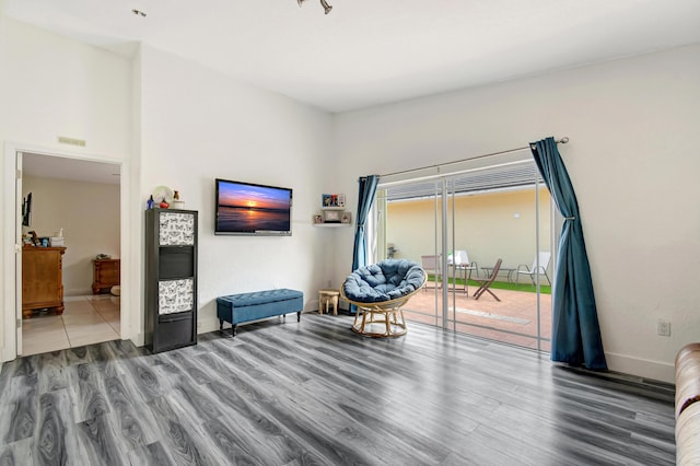 living area with wood finished floors, visible vents, and baseboards