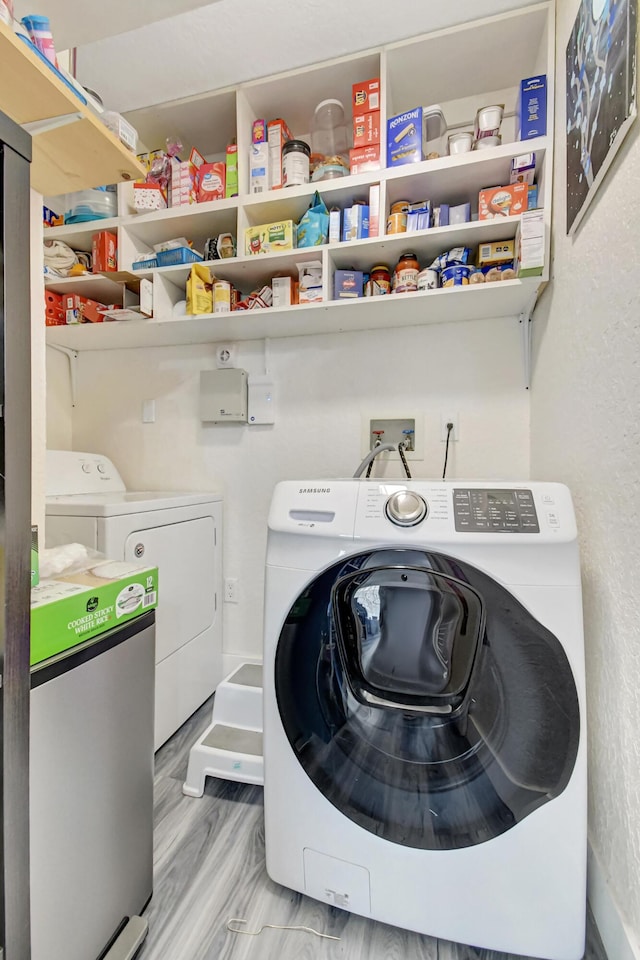 laundry area featuring laundry area, washer and clothes dryer, and wood finished floors