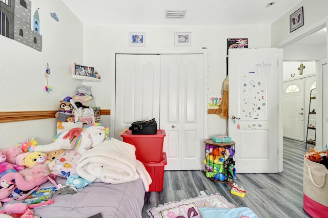 bedroom featuring a closet, visible vents, and wood finished floors