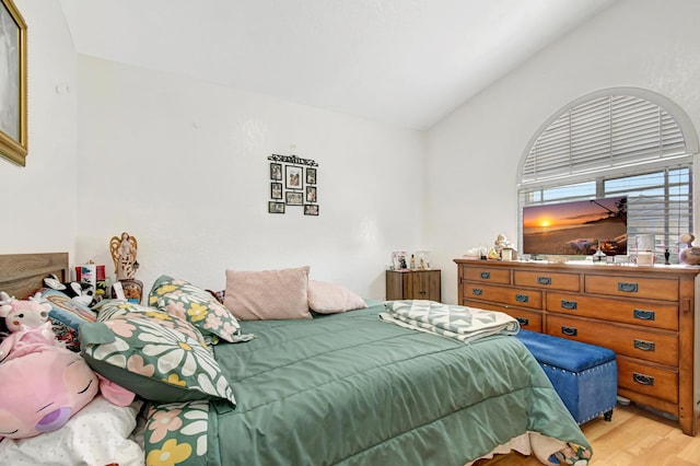 bedroom featuring light wood-style flooring and vaulted ceiling