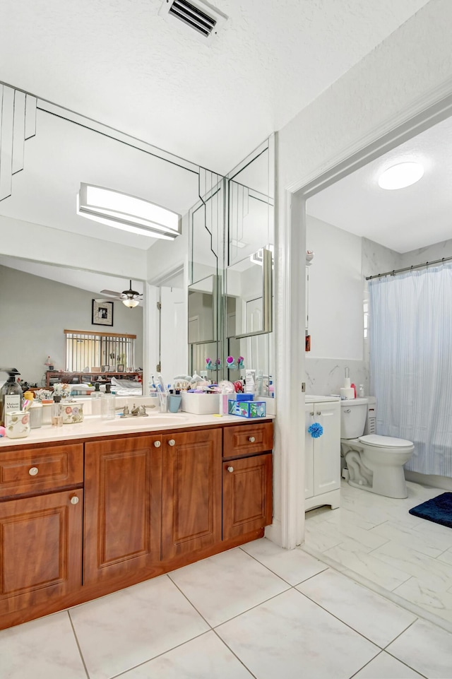 full bath featuring a shower with shower curtain, visible vents, vanity, and toilet