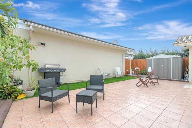 view of patio / terrace with an outbuilding, fence, area for grilling, and a shed