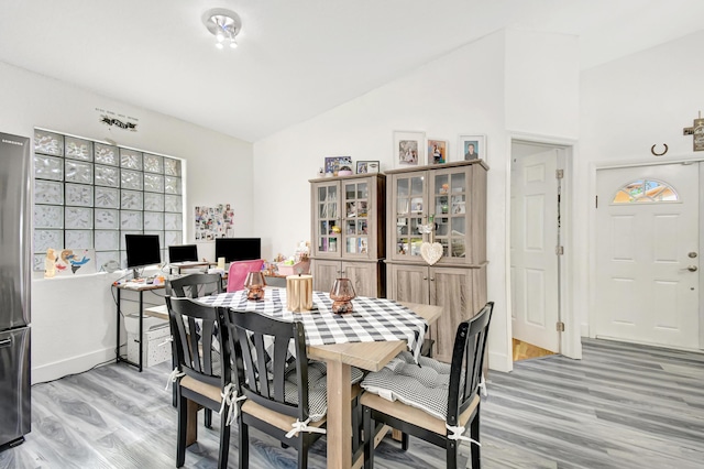 dining space with lofted ceiling and wood finished floors