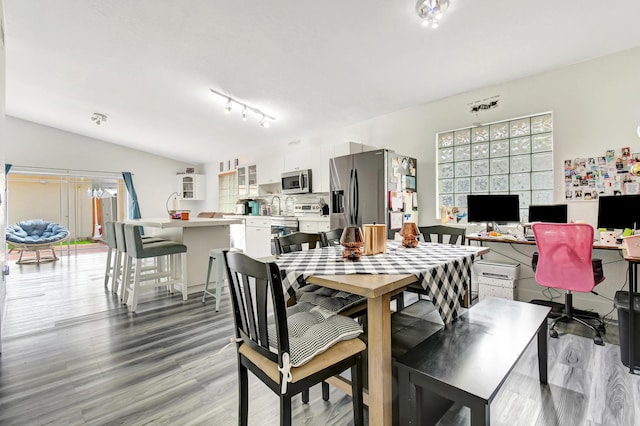 dining room with a healthy amount of sunlight, light wood-style floors, and lofted ceiling