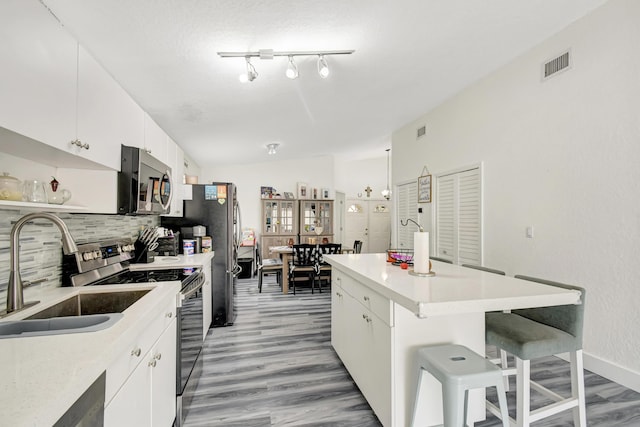 kitchen featuring appliances with stainless steel finishes, light countertops, and white cabinetry