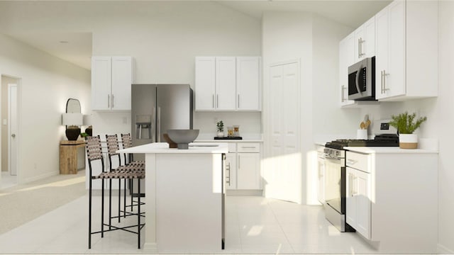 kitchen with stainless steel appliances, light countertops, a kitchen island, and white cabinetry