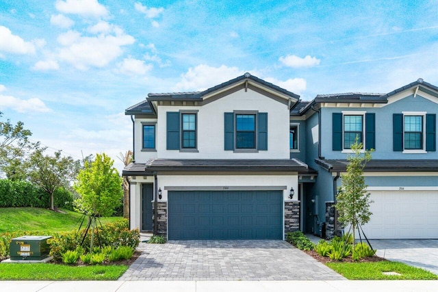 view of front of home with stone siding, decorative driveway, an attached garage, and stucco siding