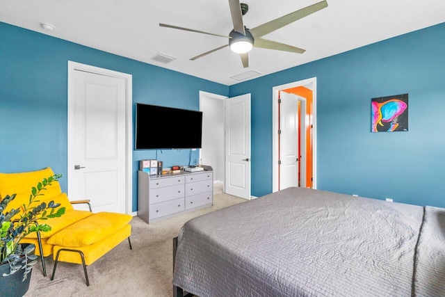 bedroom featuring light carpet, visible vents, and a ceiling fan