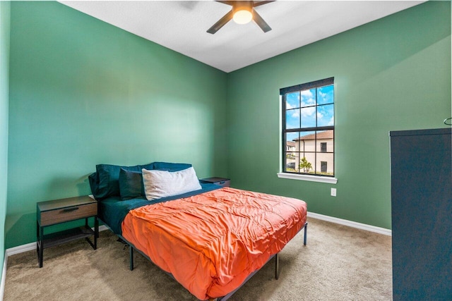 bedroom featuring light colored carpet, ceiling fan, and baseboards