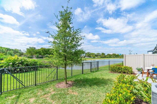 view of yard featuring a water view and a fenced backyard