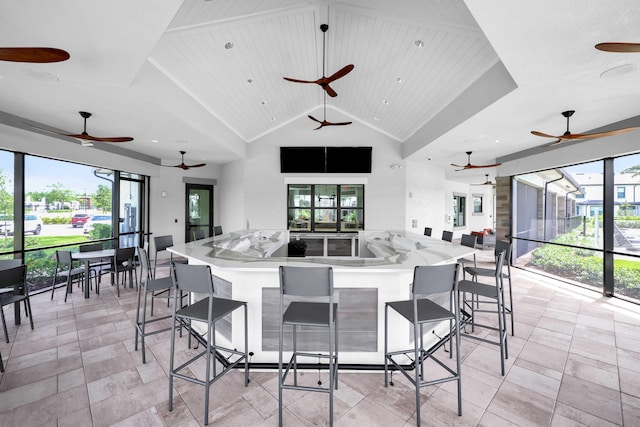 kitchen with a healthy amount of sunlight, high vaulted ceiling, open floor plan, and light countertops