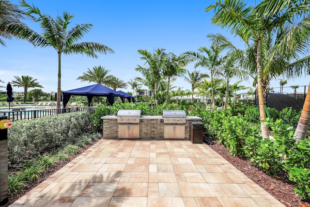 view of patio / terrace featuring a gazebo, fence, exterior kitchen, and area for grilling