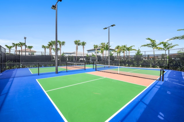 exterior space featuring a tennis court and fence