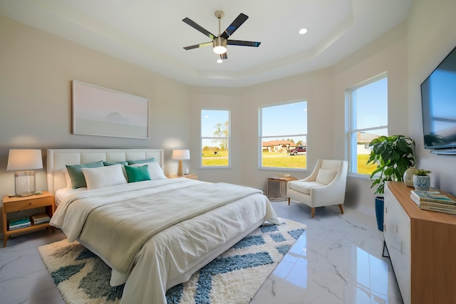 bedroom with recessed lighting, a tray ceiling, multiple windows, and marble finish floor