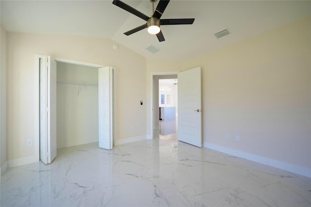 unfurnished bedroom featuring visible vents, baseboards, vaulted ceiling, a closet, and marble finish floor