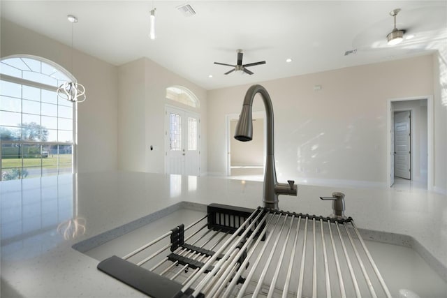 room details with recessed lighting, visible vents, stone counters, and a sink