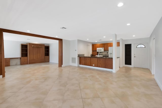 unfurnished living room with baseboards, visible vents, and recessed lighting