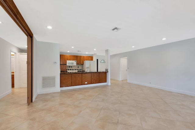 unfurnished living room with baseboards, visible vents, and recessed lighting