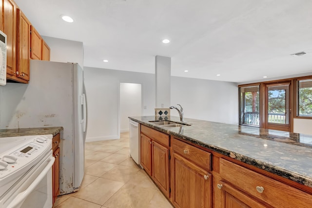 kitchen featuring white electric stove, stainless steel dishwasher, dark stone countertops, and a sink