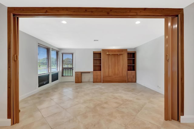 unfurnished living room featuring baseboards, light tile patterned floors, and recessed lighting