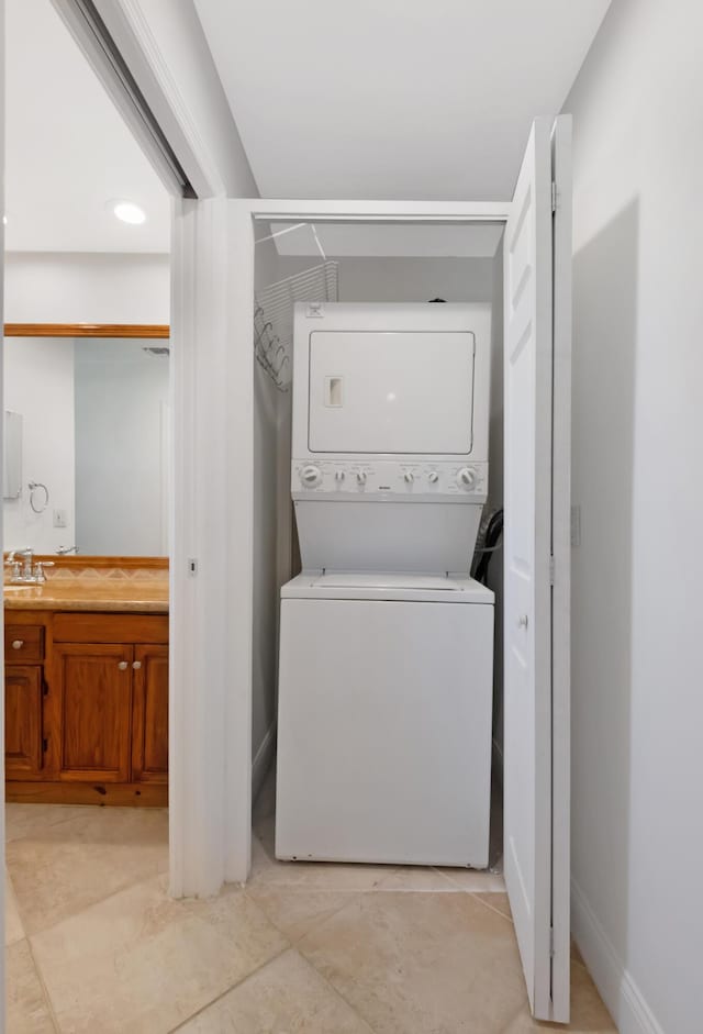 laundry area featuring laundry area, stacked washing maching and dryer, and baseboards