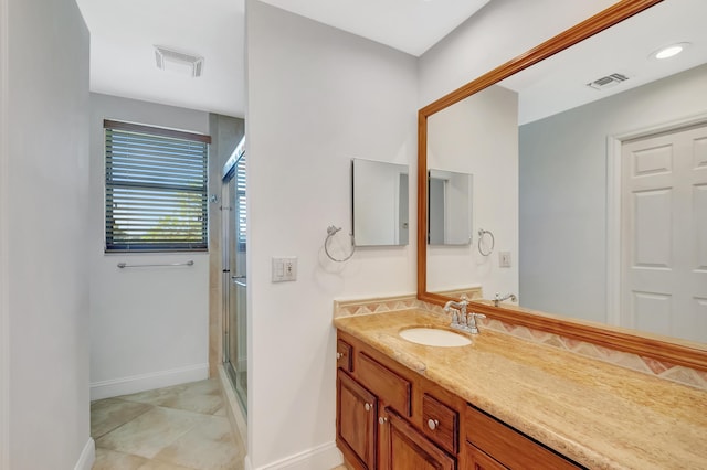 bathroom featuring a stall shower, visible vents, vanity, and baseboards