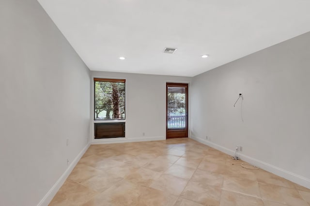 spare room with recessed lighting, visible vents, and baseboards