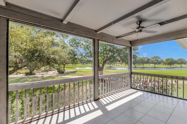 unfurnished sunroom with ceiling fan, beamed ceiling, golf course view, and a water view