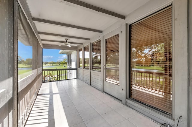 unfurnished sunroom with beam ceiling and ceiling fan