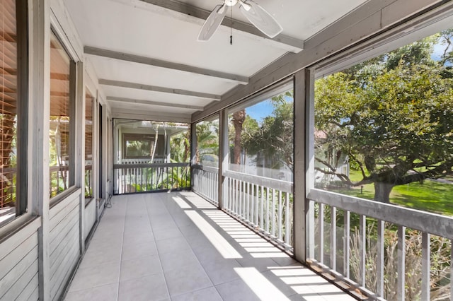 unfurnished sunroom featuring ceiling fan and beam ceiling