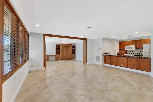 unfurnished living room with baseboards, visible vents, and recessed lighting