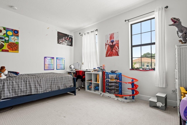 carpeted bedroom featuring a textured ceiling and baseboards